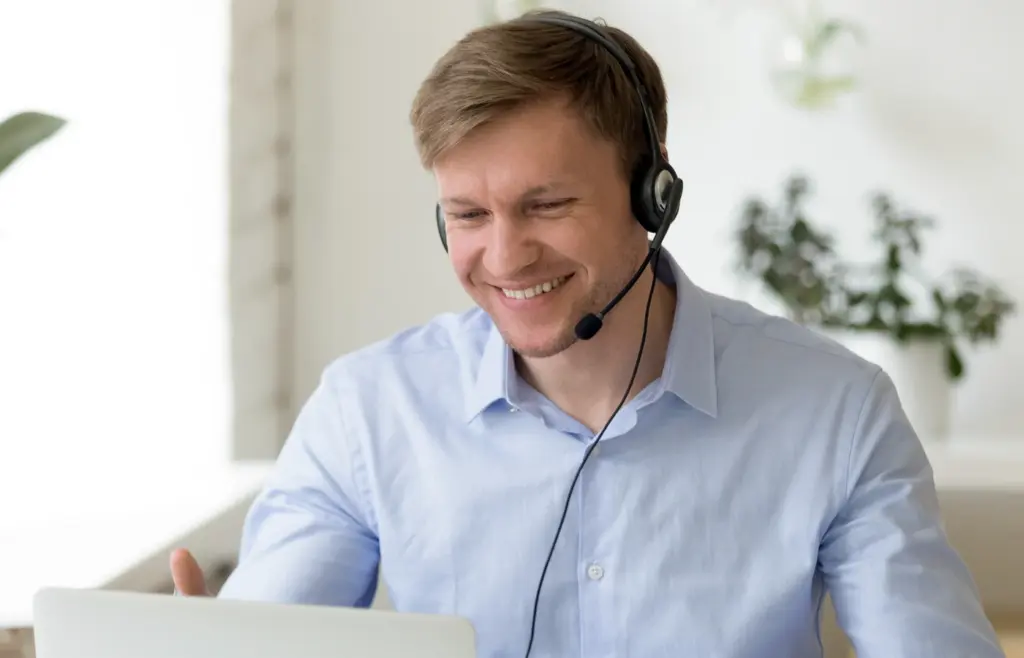 Mitarbeiter sitzt entspannt im Büro lächelt ruhig und arbeitet fokussiert nach einem Stressmanagement Training bei triup mit sofort anwendbaren Techniken