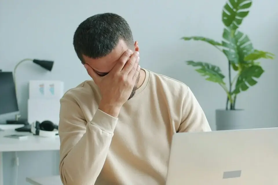 Erfolgreiches Stressmanagement: Gestresster Mitarbeiter im Büro sucht nach Lösungen zur Entlastung.