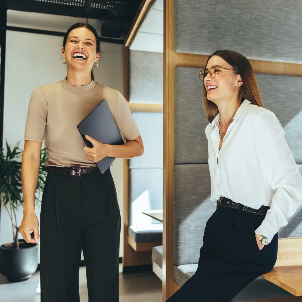Lachende Mitarbeiterinnen in einem Unternehmen als Ergebnis von wertschätzendem Führungskräfte-Coaching bei triup.